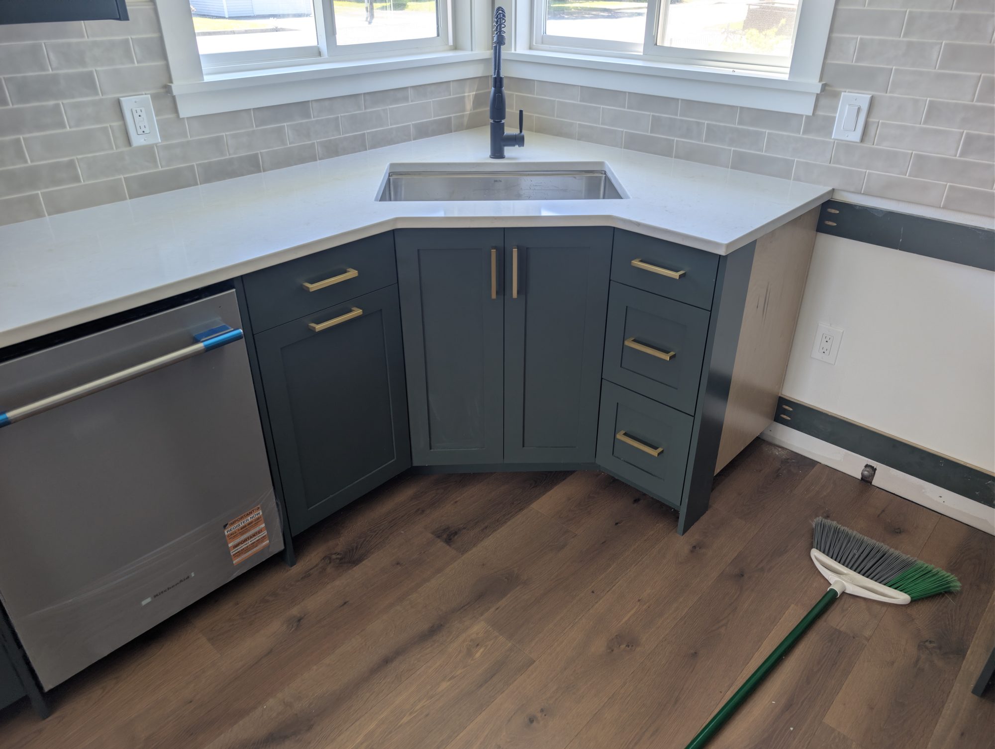 Dark shaker kitchen cabinets with quartz countertops by Premier Construction Services