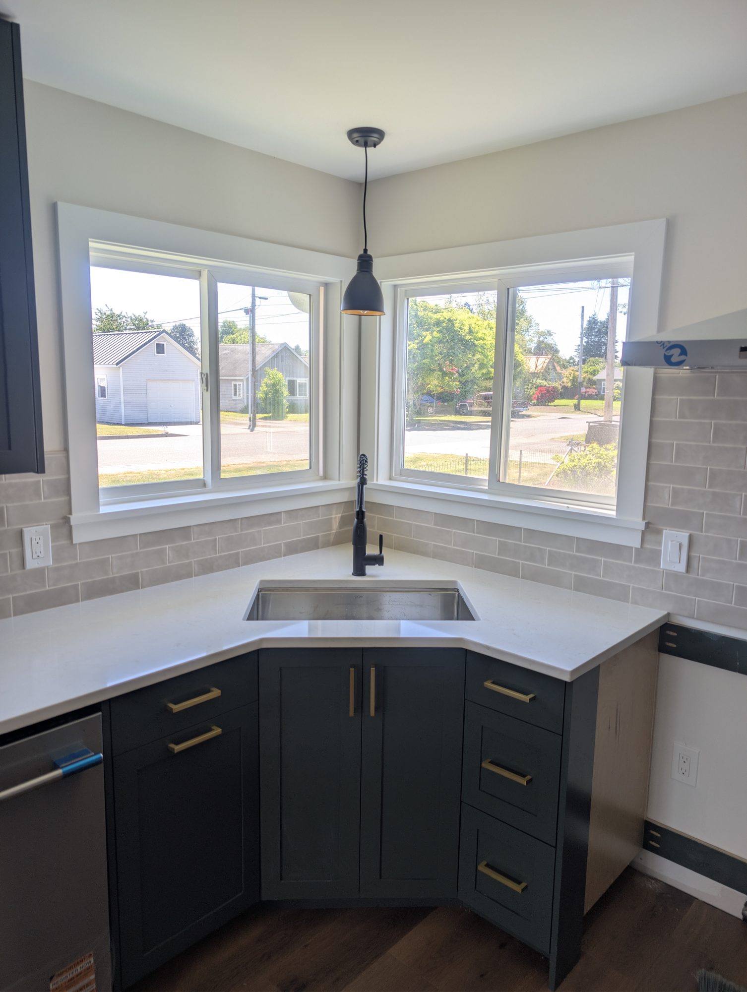 Kitchen bay window with dark cabinets and quartz counters