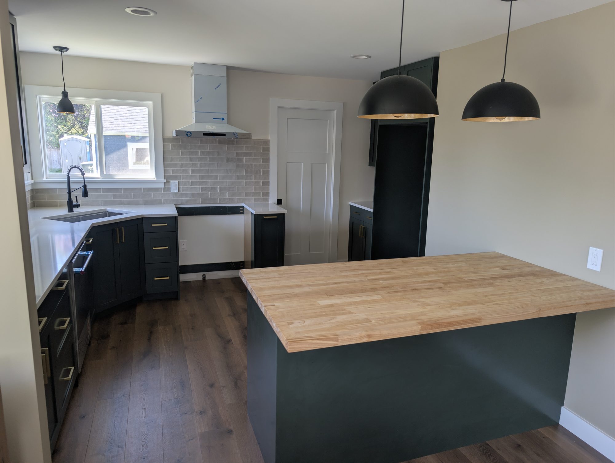 Kitchen remodel with dark cabinets and butcher-block island by Premier Construction Services in Blaine, WA