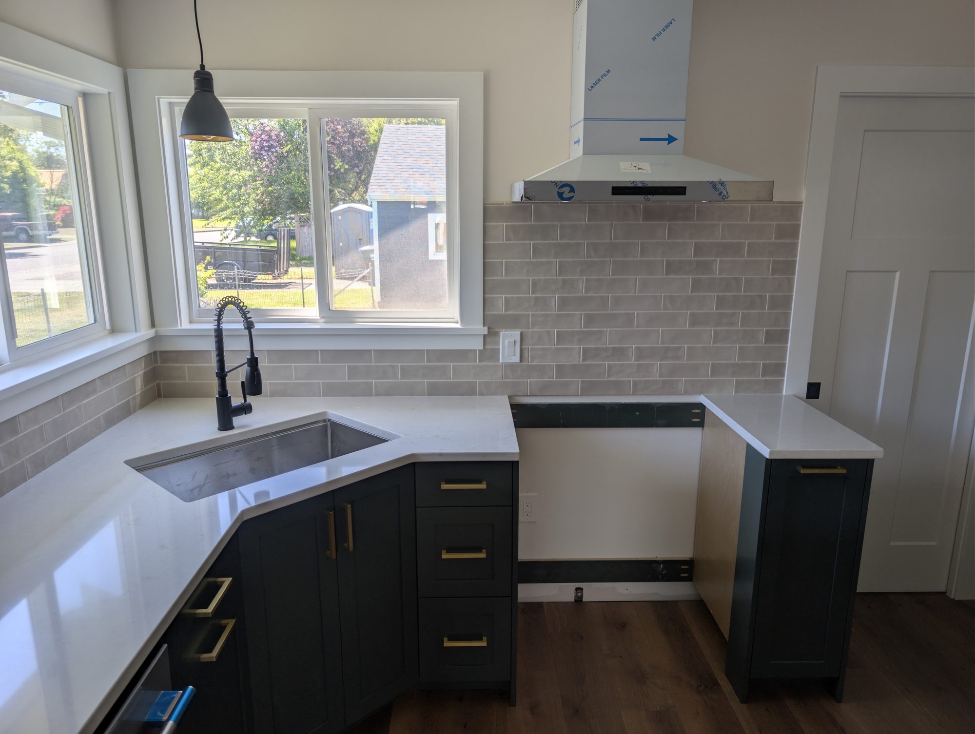 Remodeled kitchen sink and window with dark cabinets